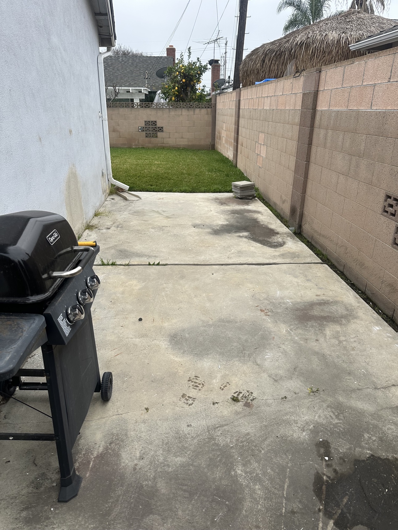 After: clean Garden Grove backyard patio with the grill left in place after debris removal
