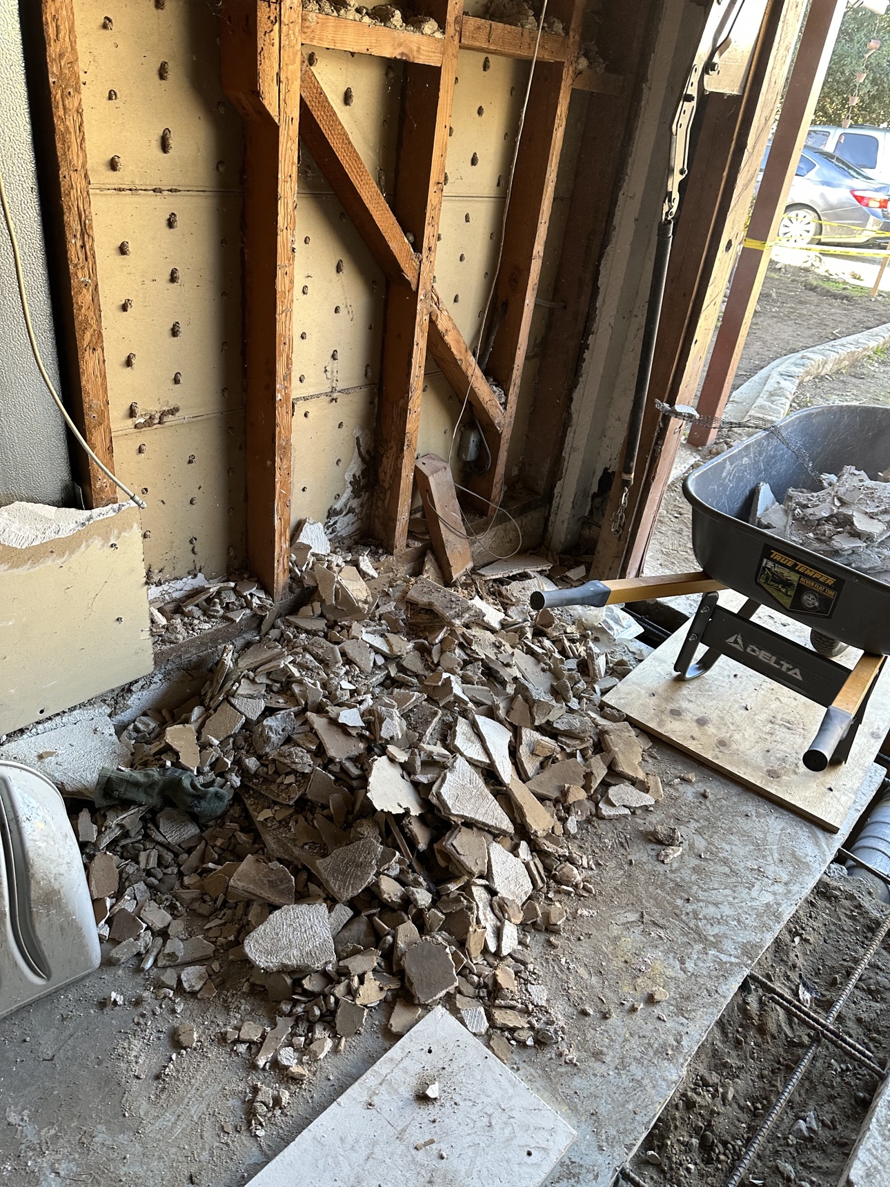 Delta-branded wheelbarrow beside demolition debris during the Riverside clean-up
