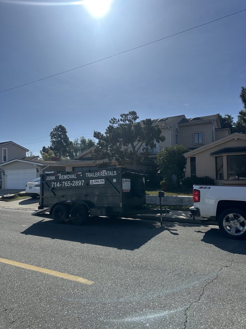 Delta dump trailer with junk removal and trailer rental branding dropped on a Laguna Woods, California street