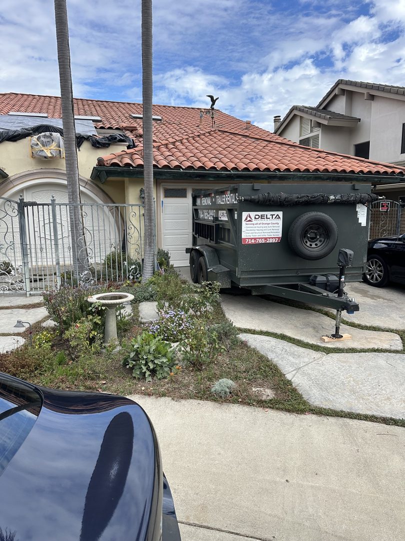 Delta dump trailer with service decal dropped at a Spanish-style house in Yorba Linda, California